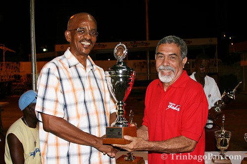 Pedro Montanez (R) receives the first place trophy for Steelband and Mas Large Band category on behalf of Exodus from Michael Marcano